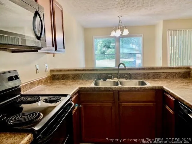 a kitchen with a sink stove top oven and cabinets
