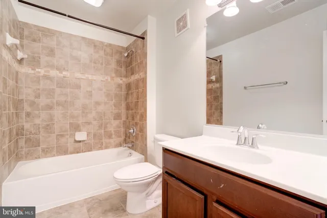 a bathroom with a sink a toilet a mirror a bathtub and shower