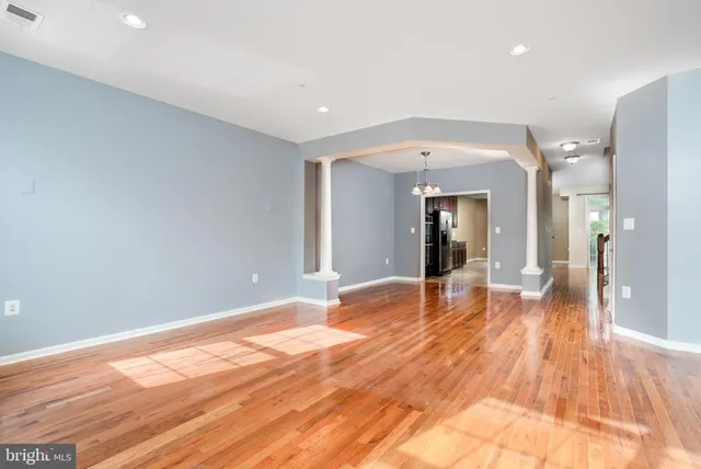 a view of empty room with wooden floor