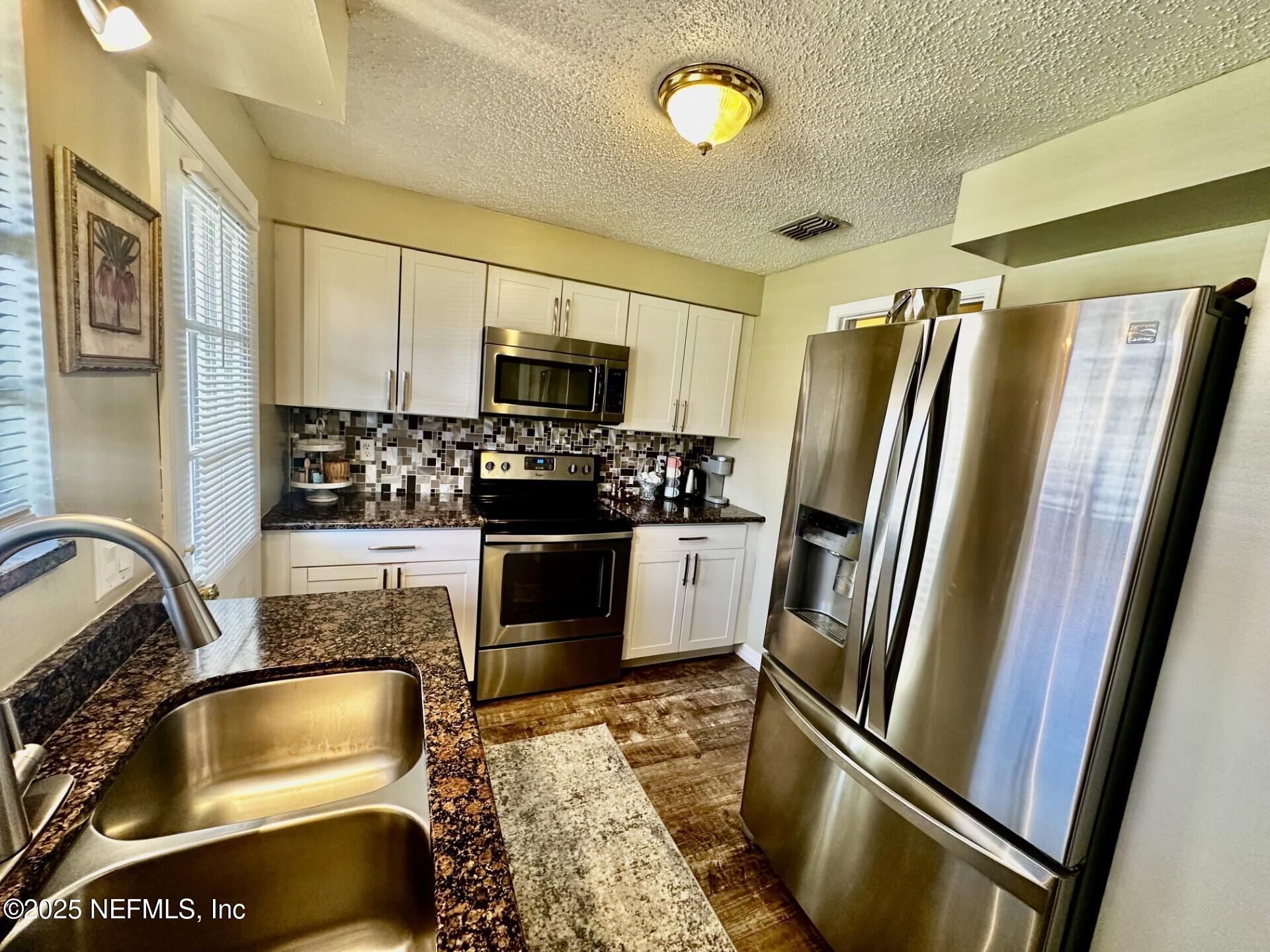 1540 El Prado Road, Unit 3 Jacksonville, FL 32216 - Photo 2 of 26 a kitchen with a refrigerator sink and stainless steel appliances