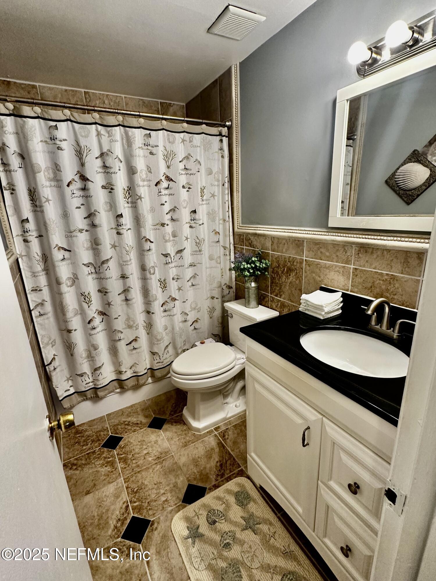 1540 El Prado Road, Unit 3 Jacksonville, FL 32216 - Photo 9 of 26 a bathroom with a granite countertop sink a toilet and a mirror