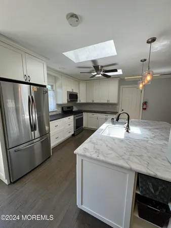 a kitchen with stainless steel appliances a sink and a refrigerator