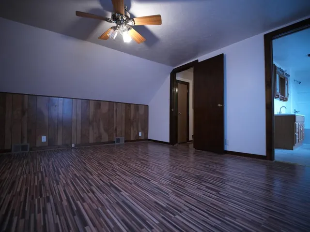 a view of a livingroom with wooden floor and a ceiling fan