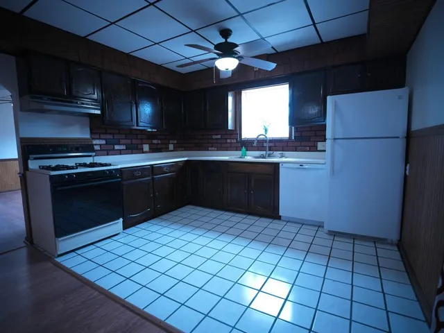 a kitchen with stainless steel appliances granite countertop a stove a sink and a refrigerator