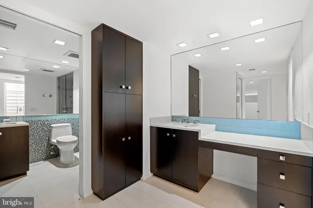 a spacious bathroom with a granite countertop sink and a mirror
