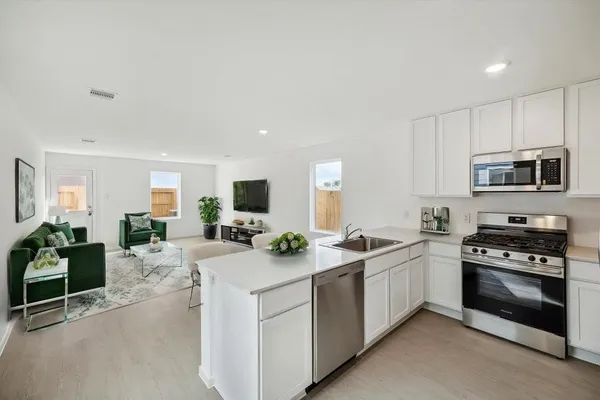 a kitchen with sink a stove and cabinets