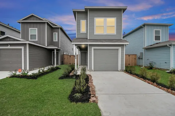 a front view of a house with a garden and yard