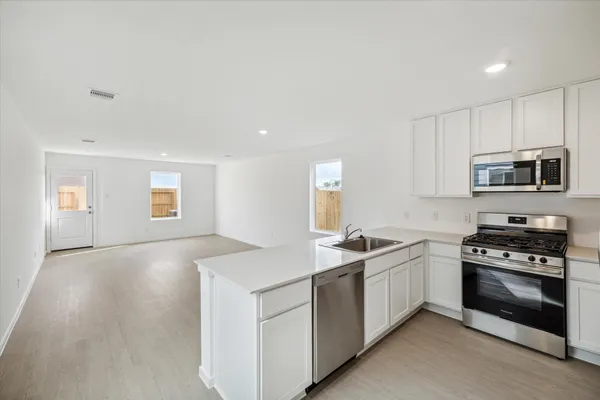 a kitchen with granite countertop a sink and steel appliances