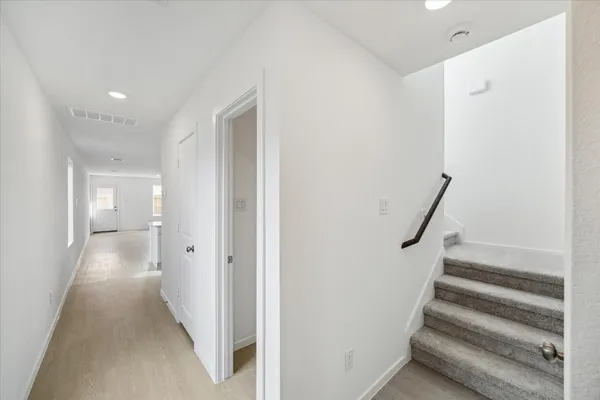 a view of a hallway with wooden floor and entryway