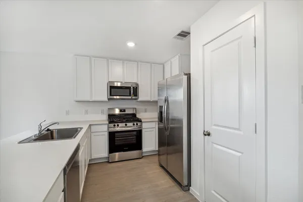 a kitchen with stainless steel appliances granite countertop a refrigerator sink and stove
