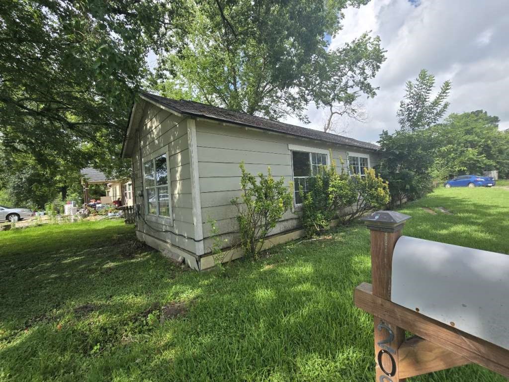 208 South 6th Street Highlands, TX 77562 - Photo 3 of 12 a view of a backyard with plants and large tree