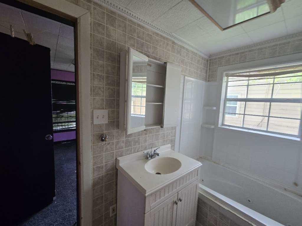 208 South 6th Street Highlands, TX 77562 - Photo 5 of 12 a bathroom with a sink and a mirror