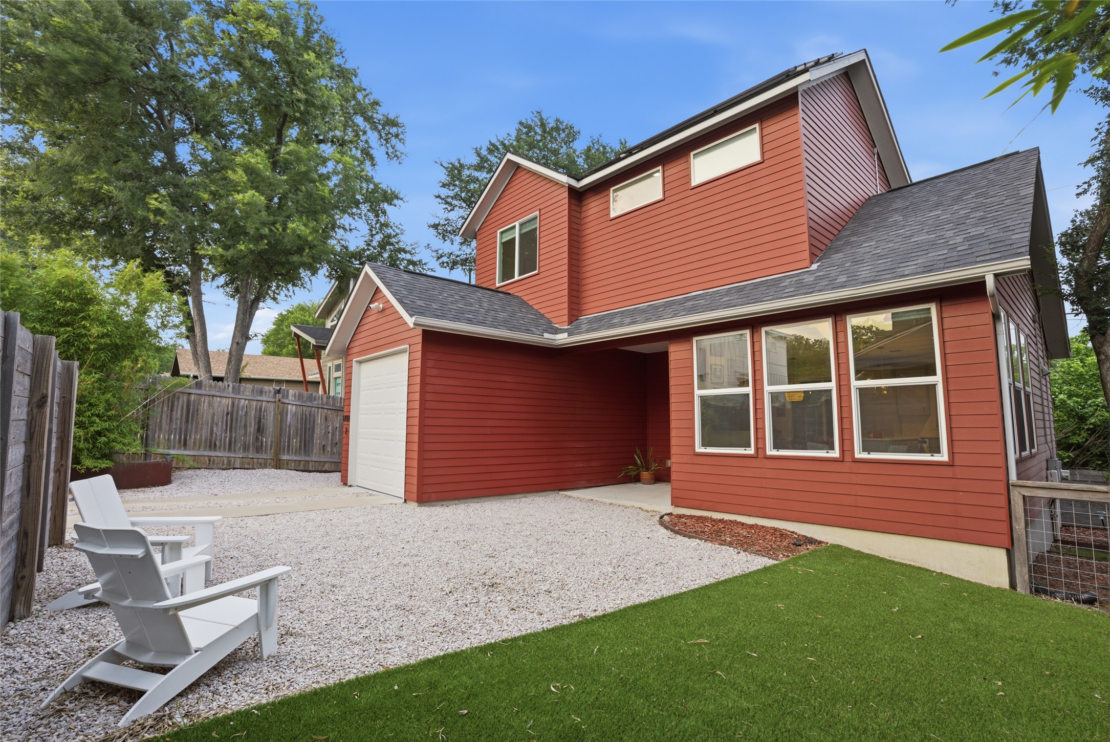 1709 Perez Street, Unit 2 Austin, TX 78721 - Photo 5 of 33 Bold red siding and a crisp white garage door highlight this contemporary exterior.