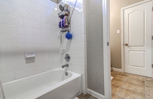 507 Rummel Ranch Run Cedar Park, TX 78613 - Photo 36 of 39 White subway tile lines a full bathtub and shower combination, ready for relaxation.