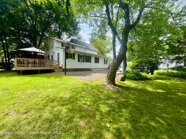 a view of a house with a big yard and large trees