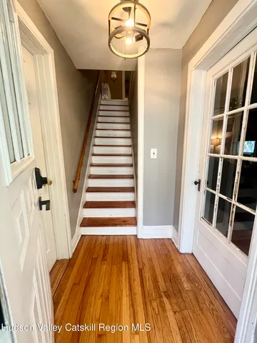 a view of a hallway with wooden floor and staircase