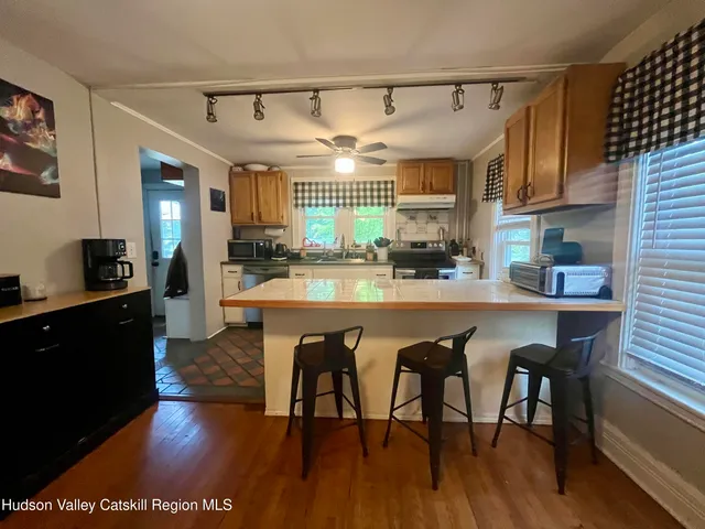 a kitchen with stainless steel appliances granite countertop a table chairs and a refrigerator