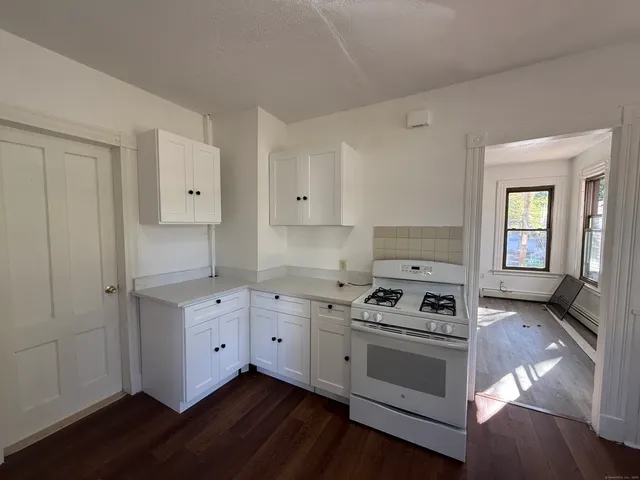 a kitchen with white cabinets and appliances