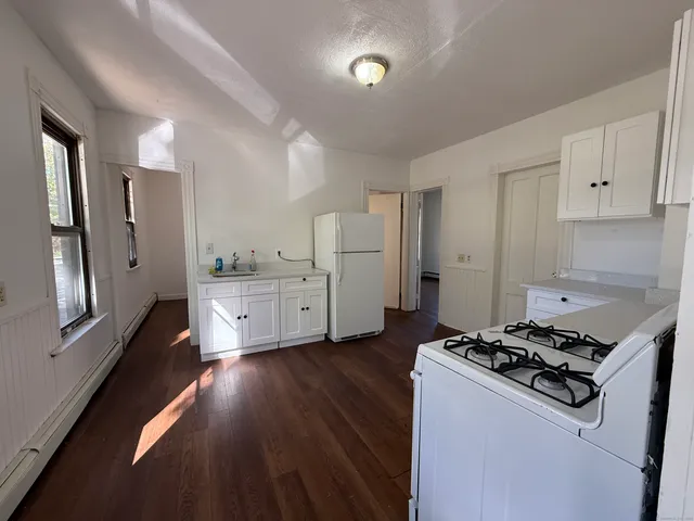 a kitchen with white cabinets and white appliances