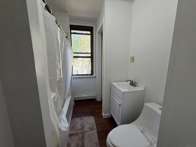 a bathroom with a sink toilet and window