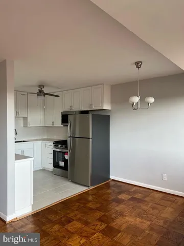 a kitchen with granite countertop a refrigerator and a stove top oven