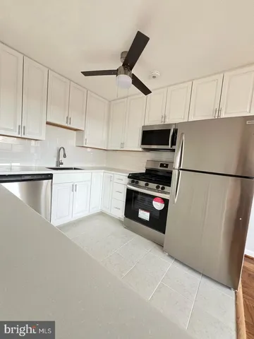 a kitchen with granite countertop a refrigerator and a sink