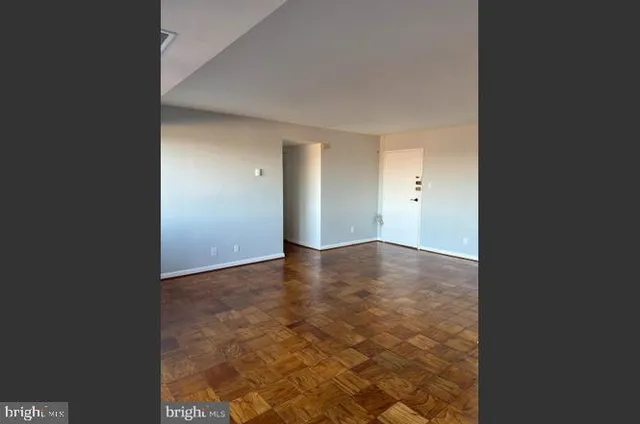 a view of empty room with wooden floor