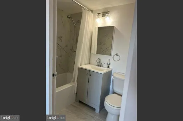 a bathroom with a sink toilet vanity and shower