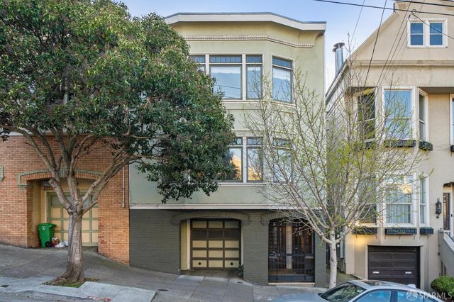 a front view of a building with a tree