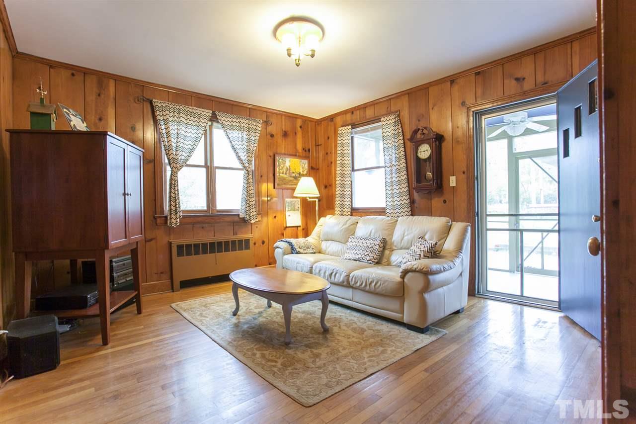 2509 Pickett Road Durham, NC 27705 - Photo 12 of 25 a living room with furniture a fireplace and a flat screen tv