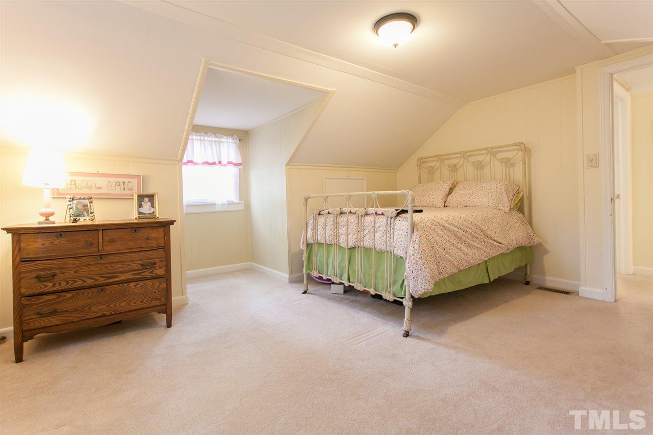 2509 Pickett Road Durham, NC 27705 - Photo 14 of 25 a bed sitting in a room next to a window