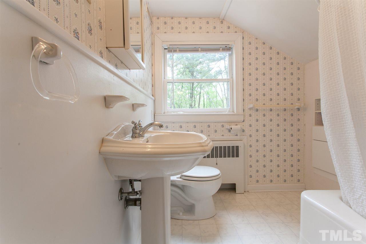 2509 Pickett Road Durham, NC 27705 - Photo 16 of 25 a bathroom with a sink a toilet and a shower