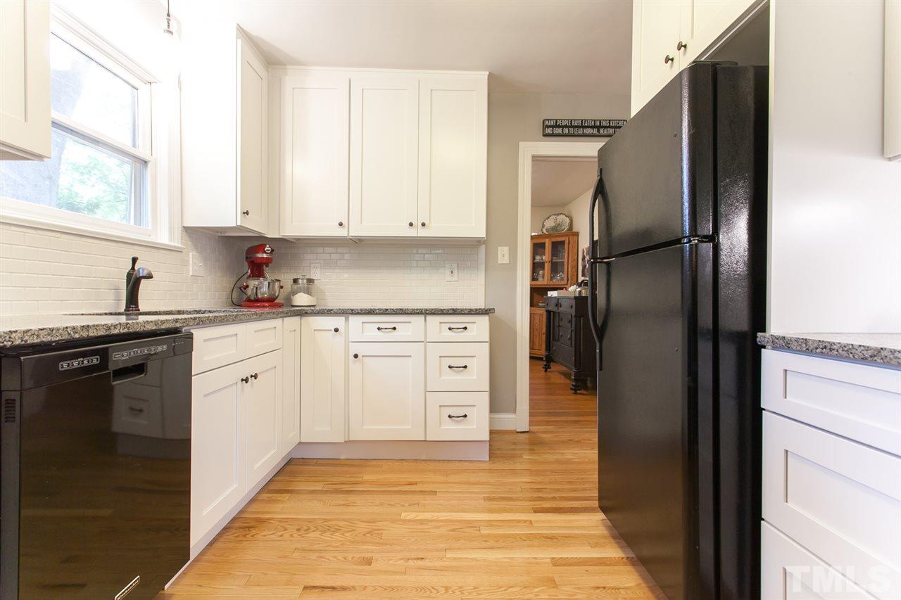 2509 Pickett Road Durham, NC 27705 - Photo 7 of 25 a kitchen with white cabinets and stainless steel appliances
