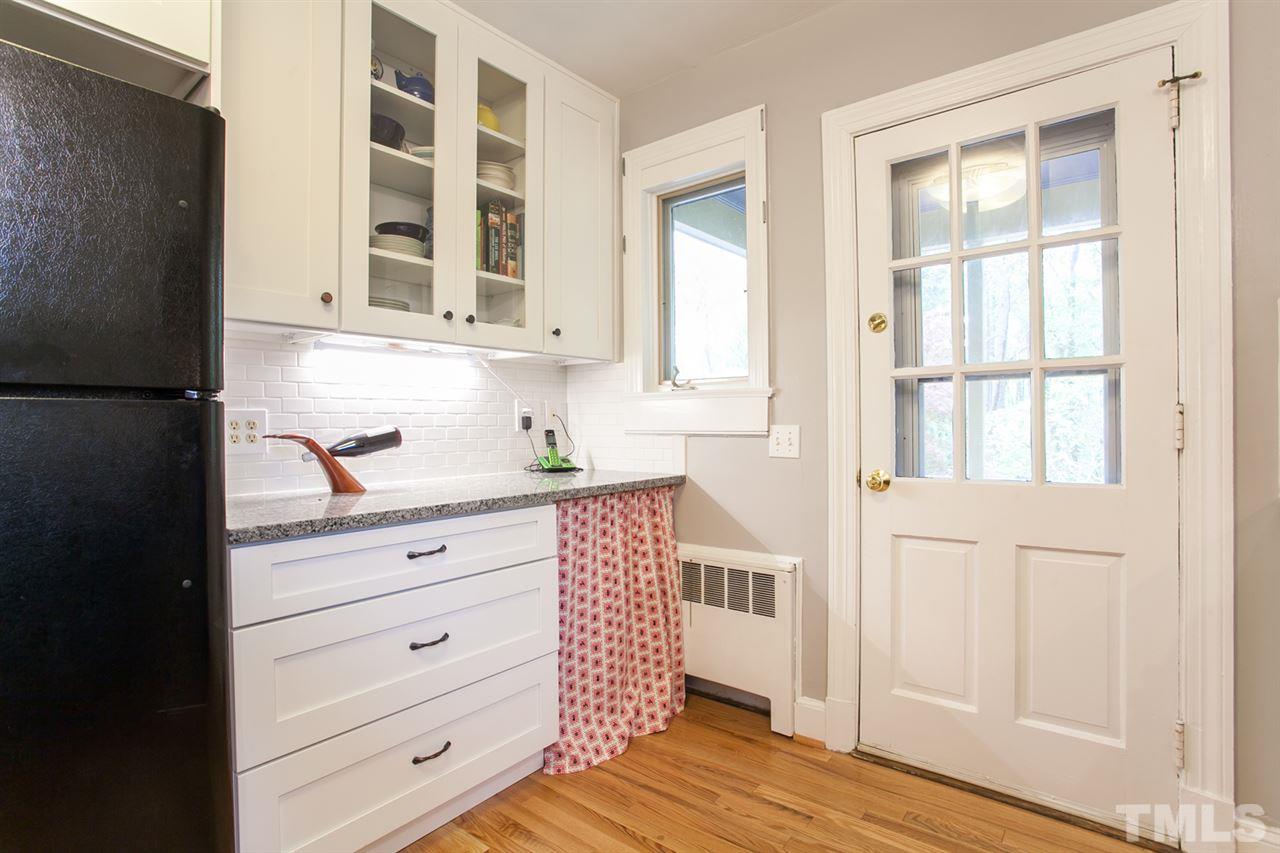 2509 Pickett Road Durham, NC 27705 - Photo 8 of 25 a kitchen with white cabinets and wooden floor