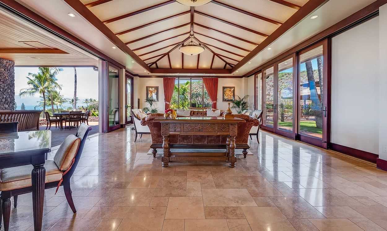 804 Anapuni Loop, Unit 63 Lahaina, HI 96761 - Photo 24 of 30 a living room with furniture a large window and a chandelier
