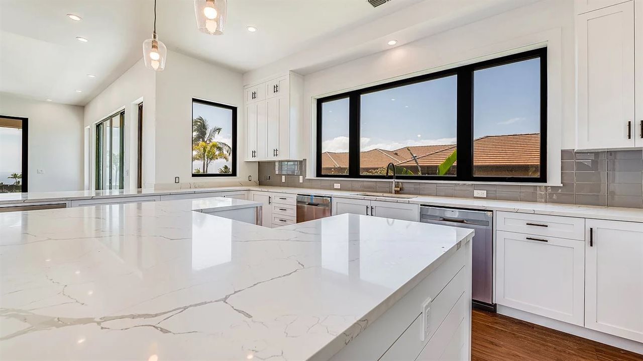 804 Anapuni Loop, Unit 63 Lahaina, HI 96761 - Photo 8 of 30 a large white kitchen with granite countertop a large window and white cabinets