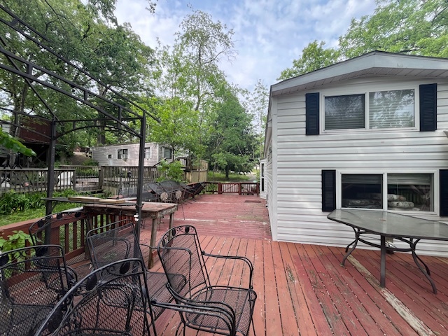 2795 East 28th Road Marseilles, IL 61341 - Photo 21 of 64 a view of a patio with table and chairs and potted plants with wooden floor and fence