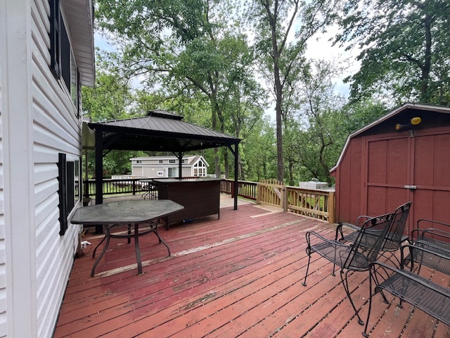 2795 East 28th Road Marseilles, IL 61341 - Photo 23 of 64 a view of deck with table and chairs under an umbrella with wooden floor