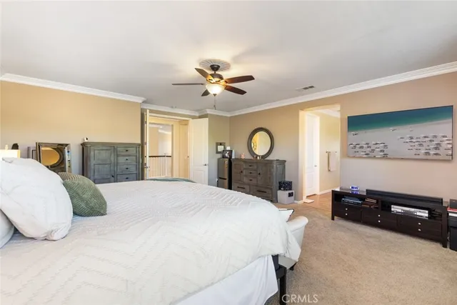 a spacious bedroom with a bed and dresser with mirror