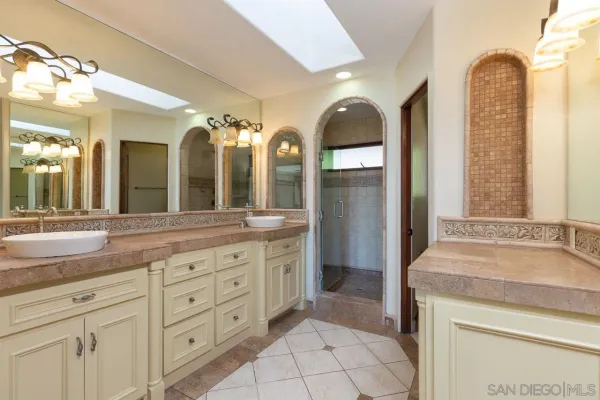 a spacious en suite bathroom with double sink and a mirror