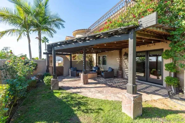 a patio with a table and chairs and potted plants