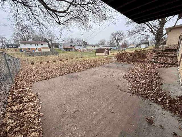a view of a yard with wooden fence