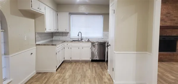 a view of a kitchen with a sink cabinets and wooden floor