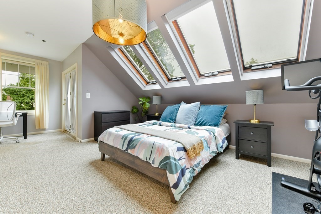 110 Maple Place, Unit 8 Dedham, MA 02026 - Photo 11 of 22 a bedroom with a bed and a chandelier