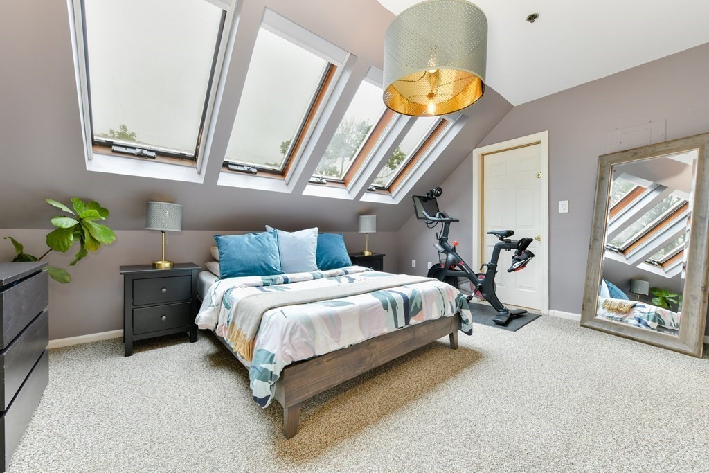 110 Maple Place, Unit 8 Dedham, MA 02026 - Photo 12 of 22 a spacious bedroom with a bed and a chandelier