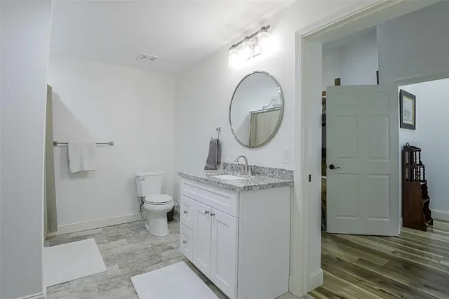 a bathroom with a toilet a sink and a mirror