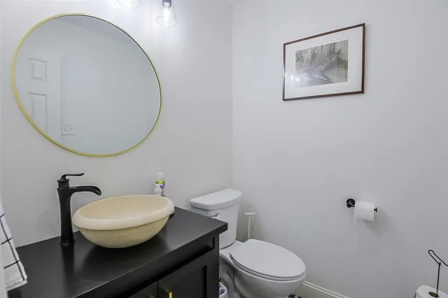 a bathroom with a toilet a sink and mirror