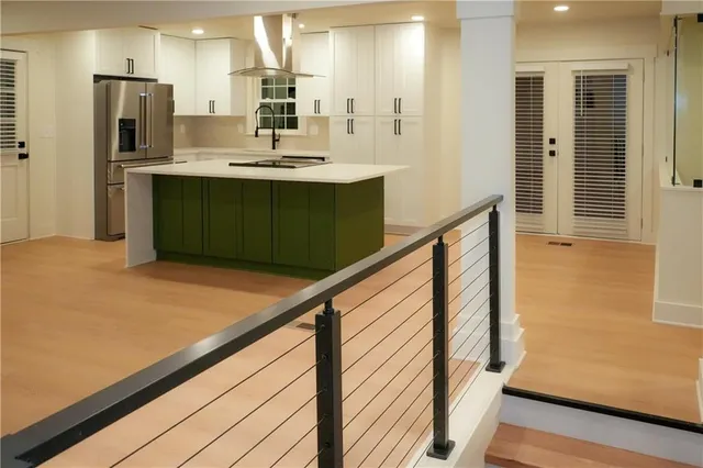a kitchen with kitchen island a sink appliances and cabinets