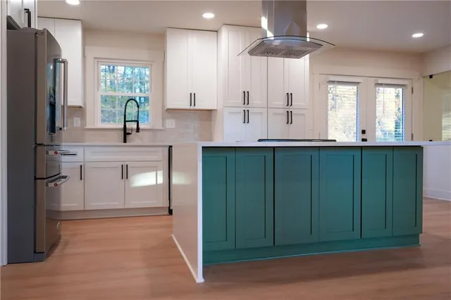a kitchen with kitchen island granite countertop a sink stainless steel appliances and cabinets
