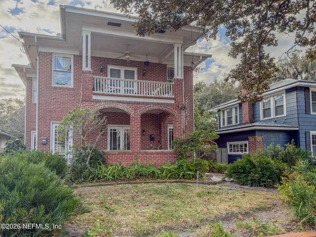 front view of a brick house with a yard